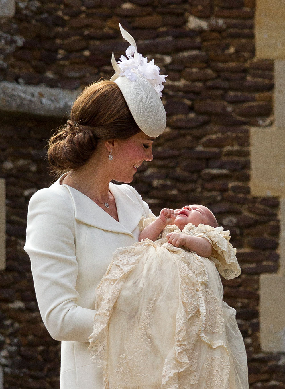 Princess Charlotte was dressed in a custom Honiton lace and white satin gown designed by the Queen’s dressmaker, Andrea Kelly. It is a replica of the 174-year-old gown worn to royal christenings for generations, including that of her brother Prince George.