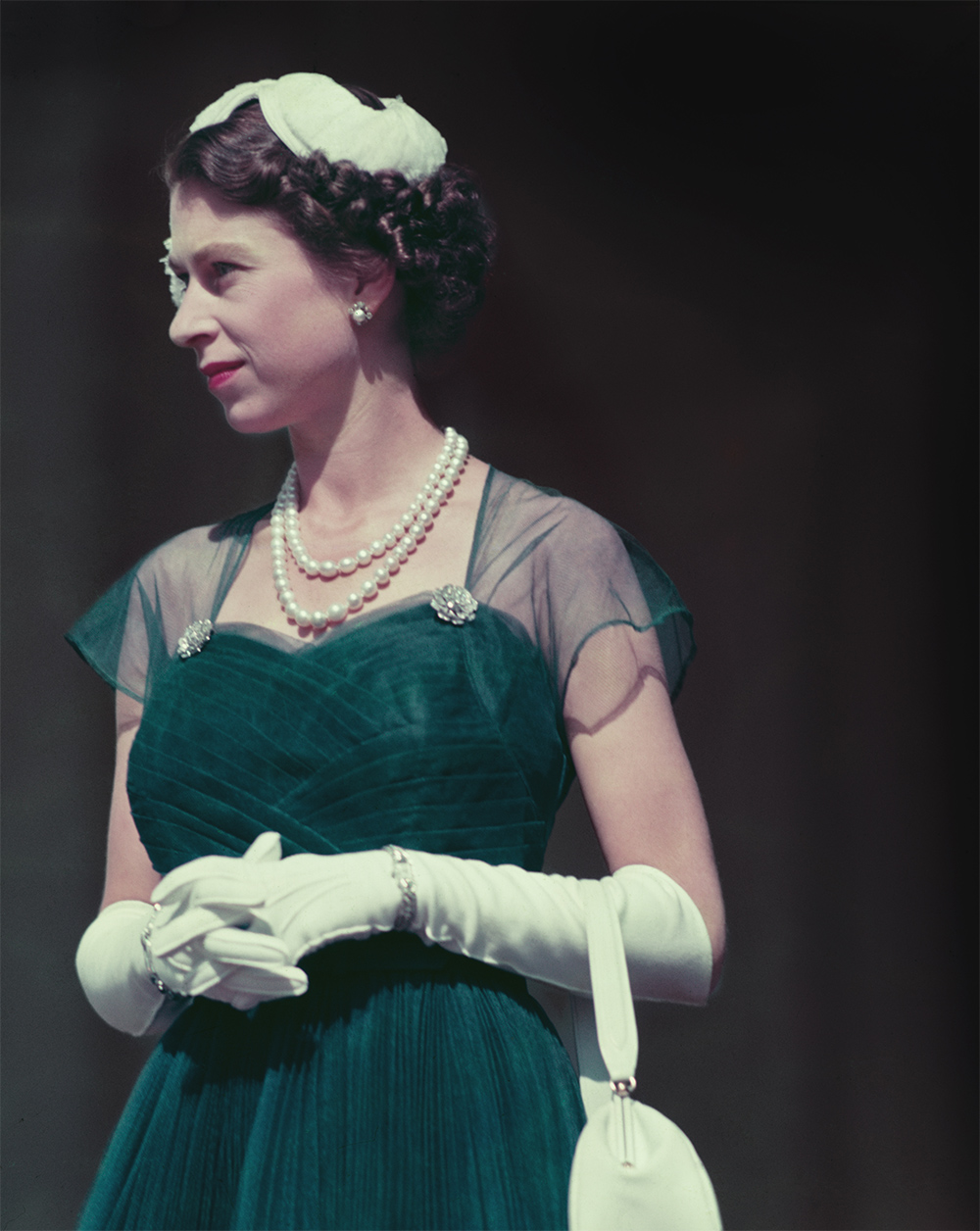 Queen Elizabeth II on the balcony of Government House, Melbourne wearing a deep green velvet dress with sheer cap sleeves during her tour of Australia in March 1954. Photo / Getty Images