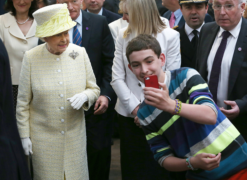 Proving she's as selfie-ready as Kim Kardashian, the Queen wears photo-friendly pastel yellow during a visit to Belfast, Northern Ireland in 2014. Photo / Getty Images