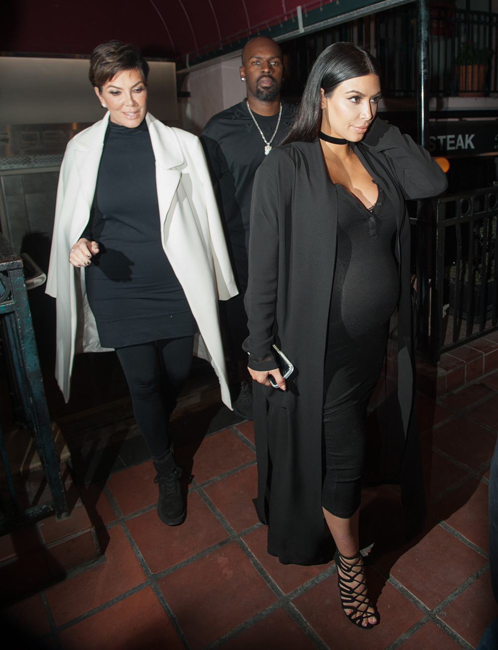 SEPTEMBER 22, 2015: Kim steps out with her mother Kris Jenner wearing a figure-hugging black dress, black duster coat, choker and caged sandals. Photo / Getty Images