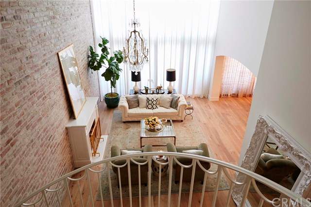 Lauren's two-story living room was redone to highlight the 20 foot reclaimed brick wall and custom spiral staircase.