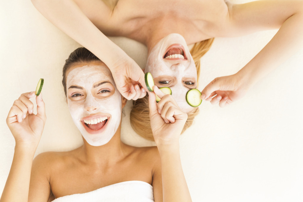 Women with cucumber slices on eyes and facial masks