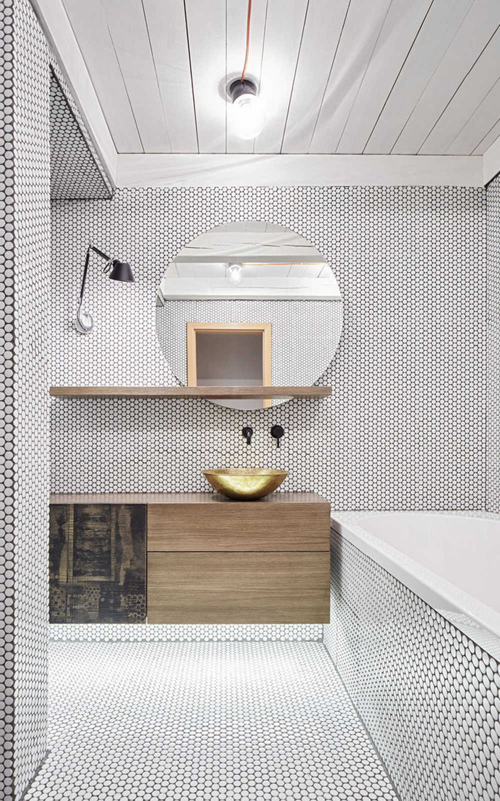 Circle tiled bathroom with gold basin and wooden ceiling
