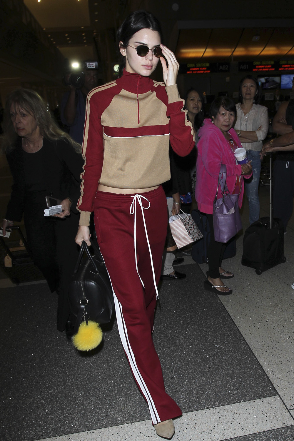 Model Kendall Jenner is on trend in a red and beige Chloe tracksuit arriving at LAX.