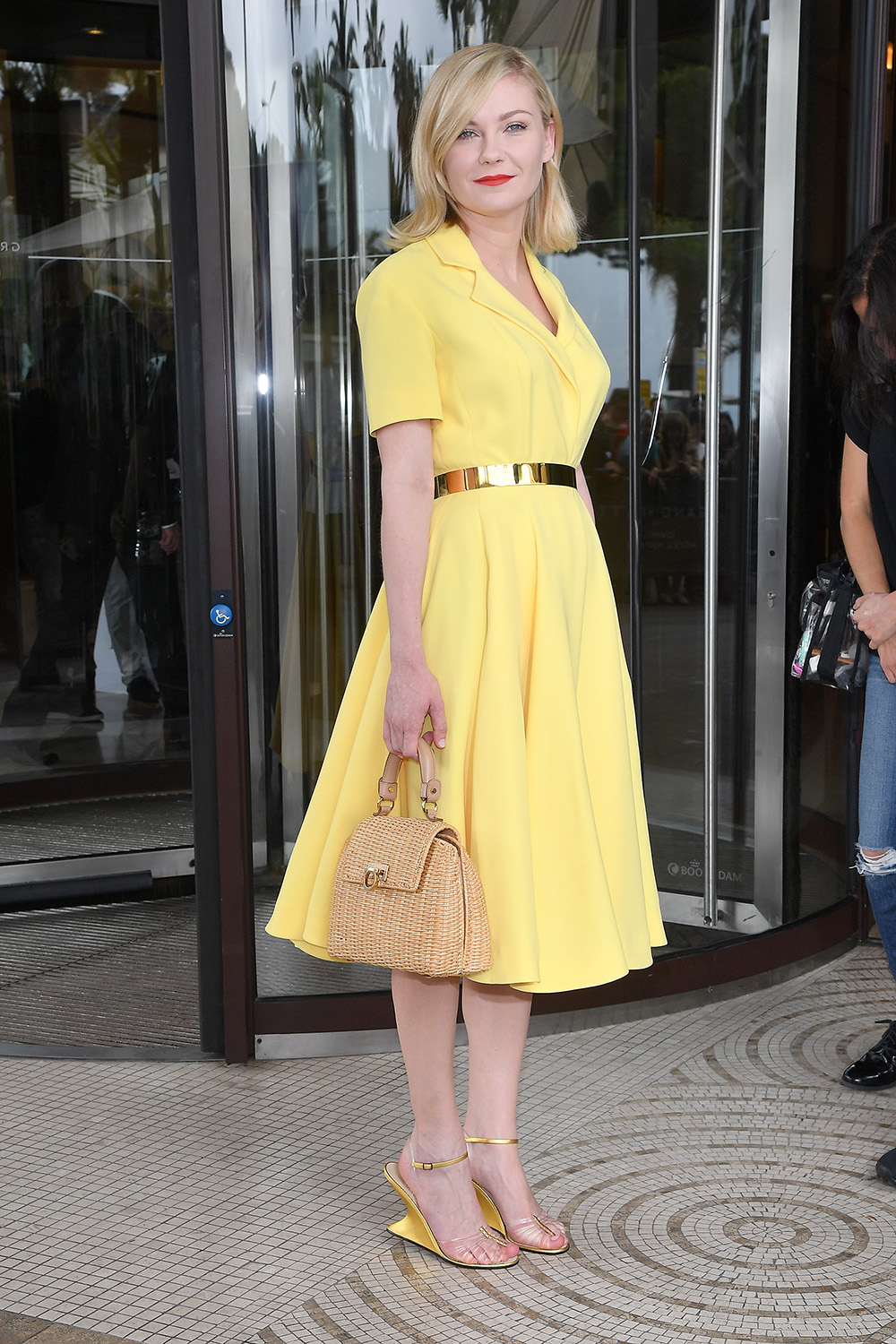 Kirsten Dunst looks impeccable in a yellow Dior dress and wicker basket handbag outside the Hotel Martinez in Cannes.