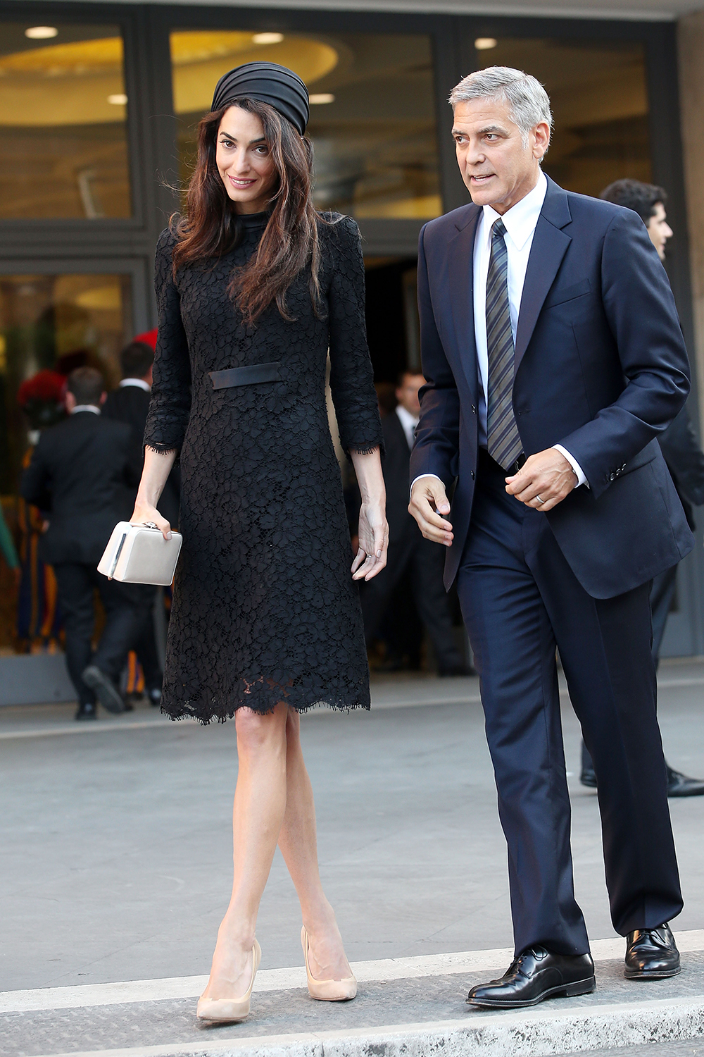 Amal Clooney looked elegant in a black Atelier Versace lace dress and silk hat with husband George Clooney for their meeting with Pope Francis at the Vatican.