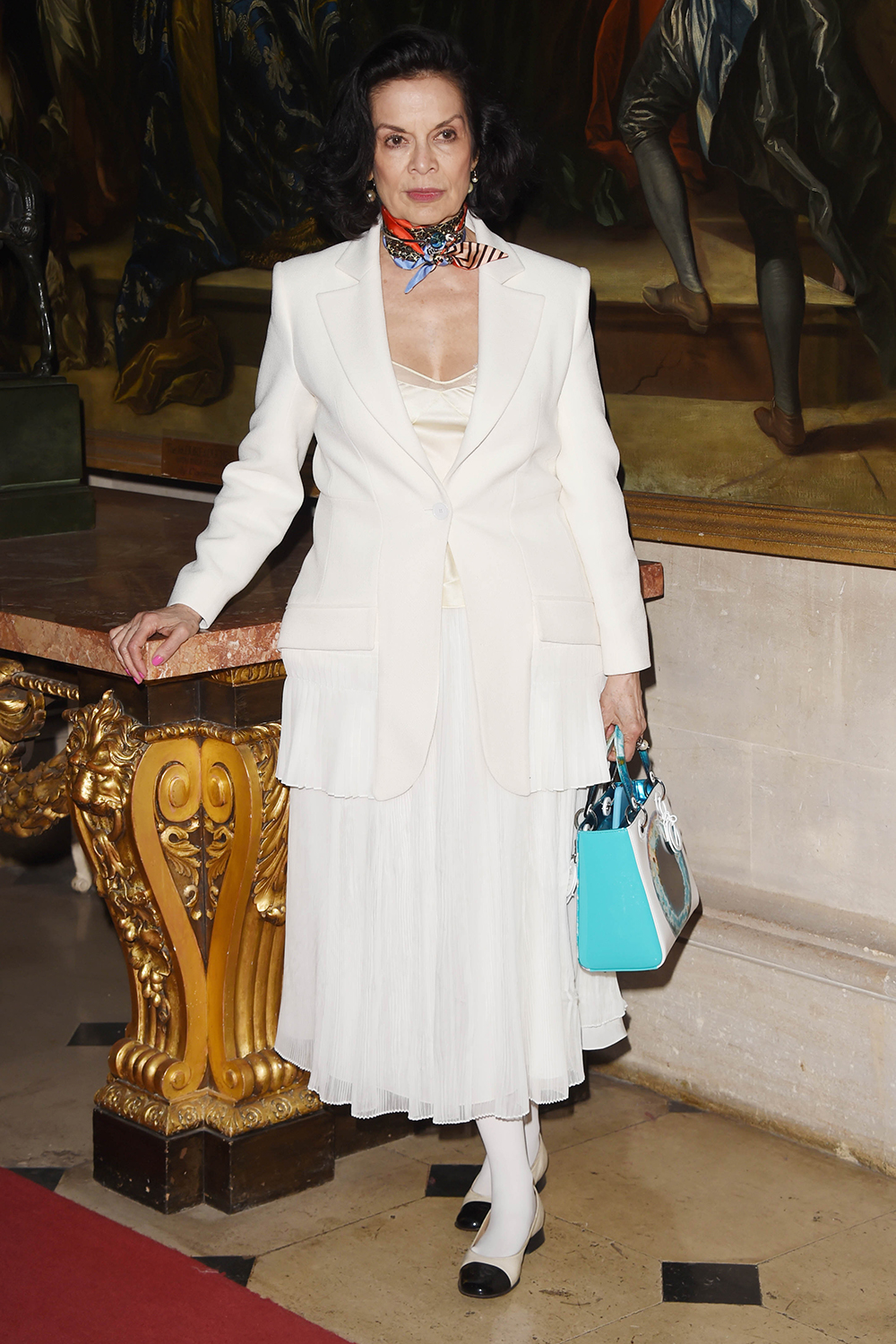 Bianca Jagger takes a note out of her own style book in a white Le Smoking jacket and skirt at Christian Dior's spring summer 2017 Cruise collection at Blenheim Palace in England.