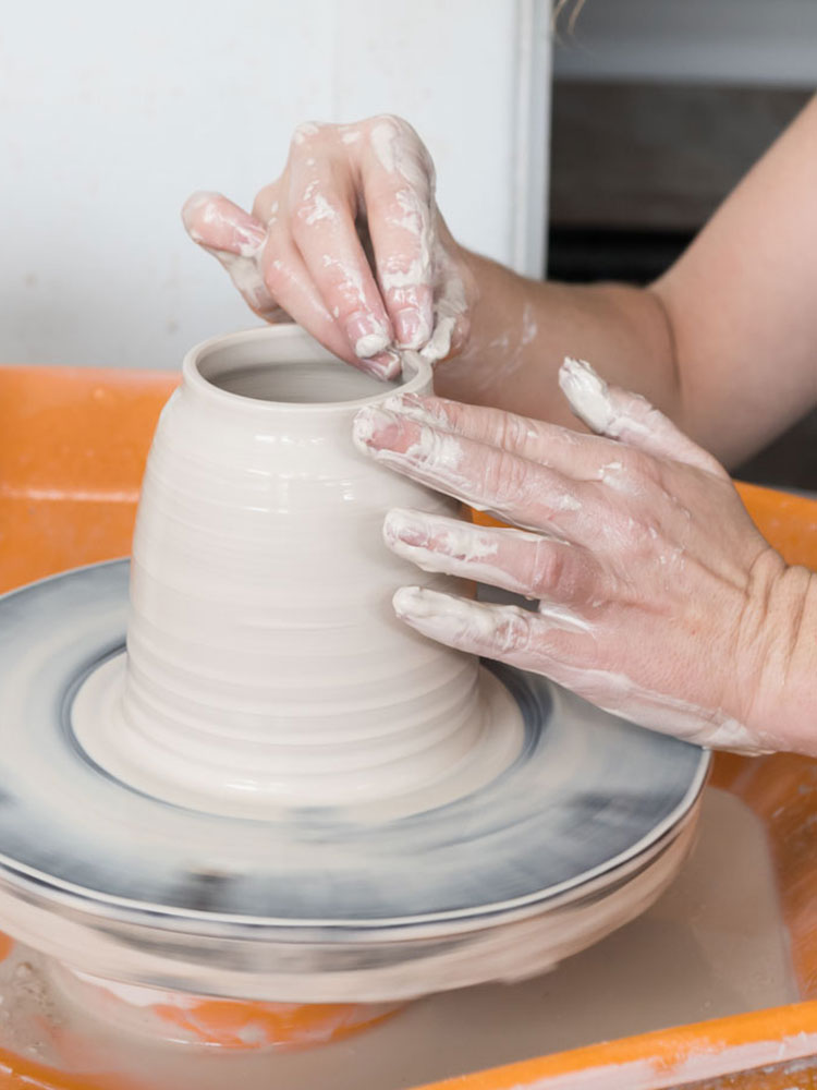 Holly Houston from Houston Design Co. forming clay at the wheel