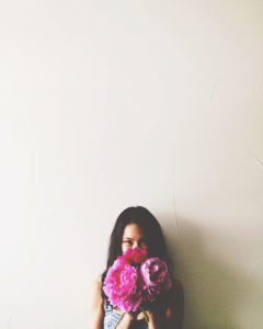 woman holding pink flowers