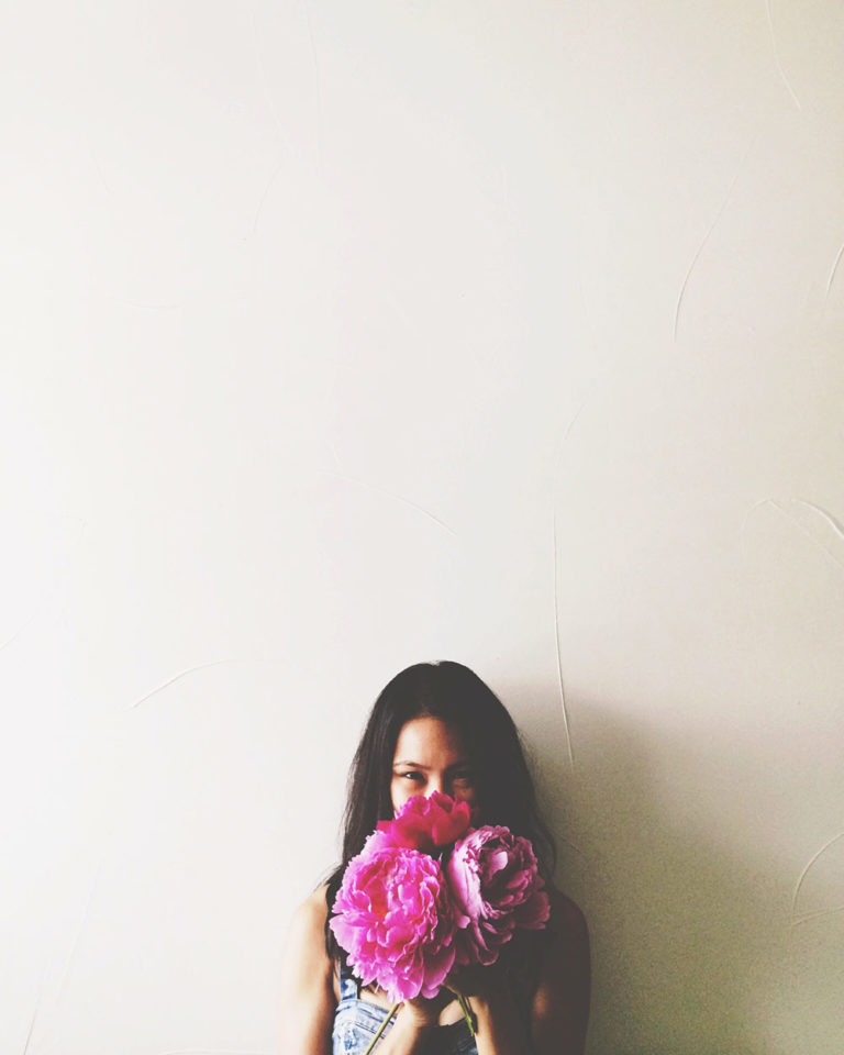 woman holding pink flowers