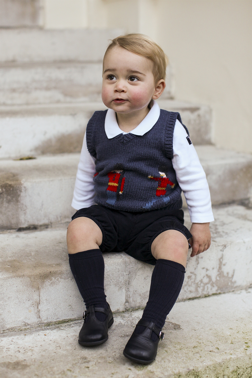 George shows off his cheeky side on the steps of Kensington Palace, during a portrait for the royal Christmas card in December, 2014.