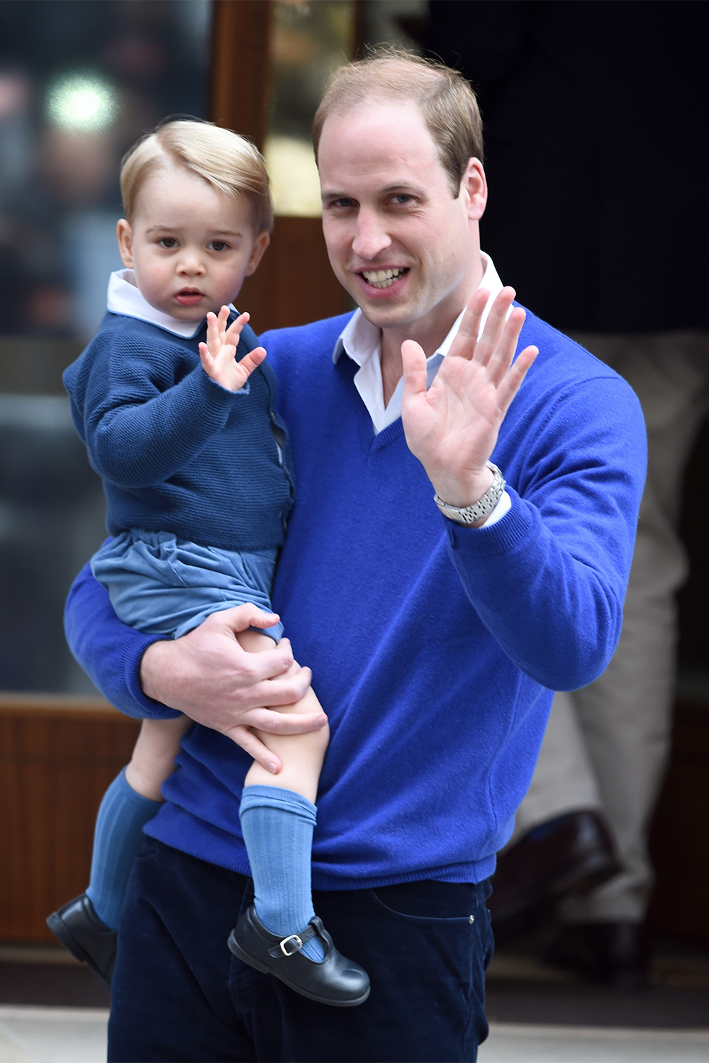Prince George waves to the crowds as he arrives at the Lindo Wing at St. Mary's Hospital with his father Prince William to meet his new sister Princess Charlotte on May 2, 2015.
