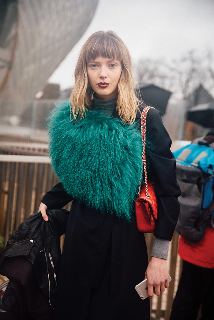 Danish model Ulrikke Hoeyer wears a green fur shawl and red Chanel purse over a black outfit after the Louis Vuitton show on Day 9 of PFW FW16 on March 09, 2016
