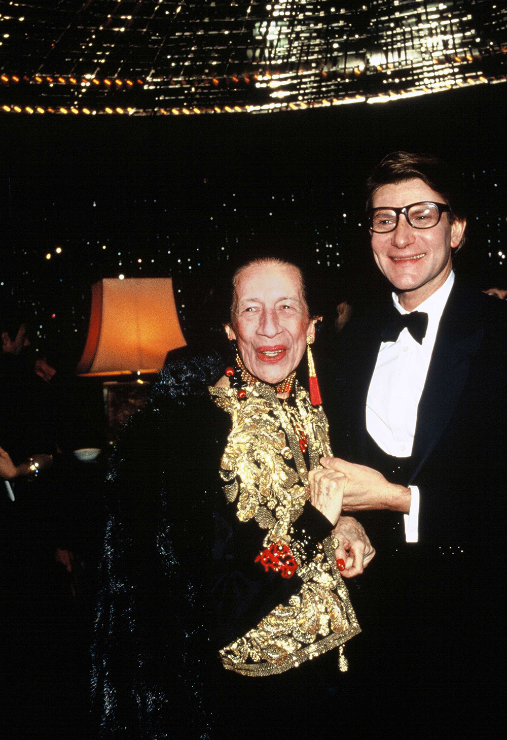 PARIS,FRANCE - NOVEMBER 1982: French fashion designer Yves Saint Laurent with Diana Vreeland, the legendary editor of Harper's Bazaar and Vogue attend the Yves Saint Laurent 20th Anniversary Gala at the Lido Cabaret during November 1982 in in Paris,France. (Photo by Georges DeKeerle/Getty Images)