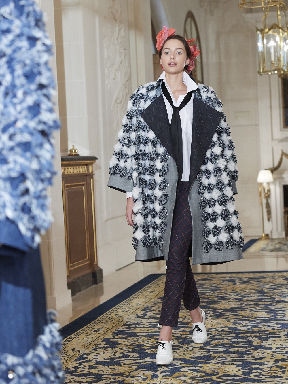 A model wear a checked coat and trousers on the runway at Chanel's pre-fall 2017 collection at The Ritz