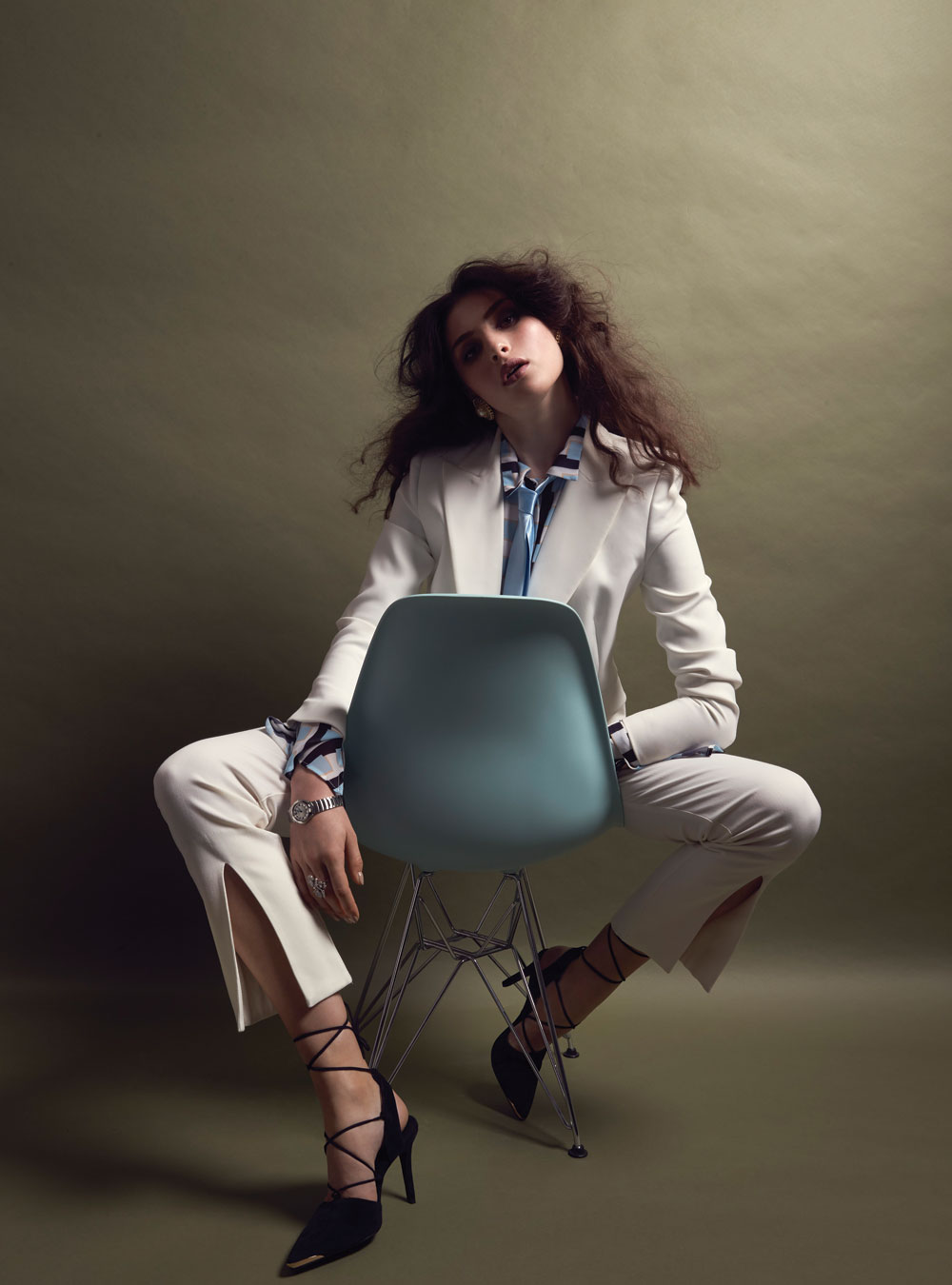 Camilla and Marc blazer, $990. Coop shirt, $179. Taylor pants, $427. Stylist’s own tie and earrings. Karen Walker ring, $24,279. Louis Vuitton watch, $7150. Senso heels, $289. Charles and Ray Eames chair, $450, from Mr. Bigglesworthy.