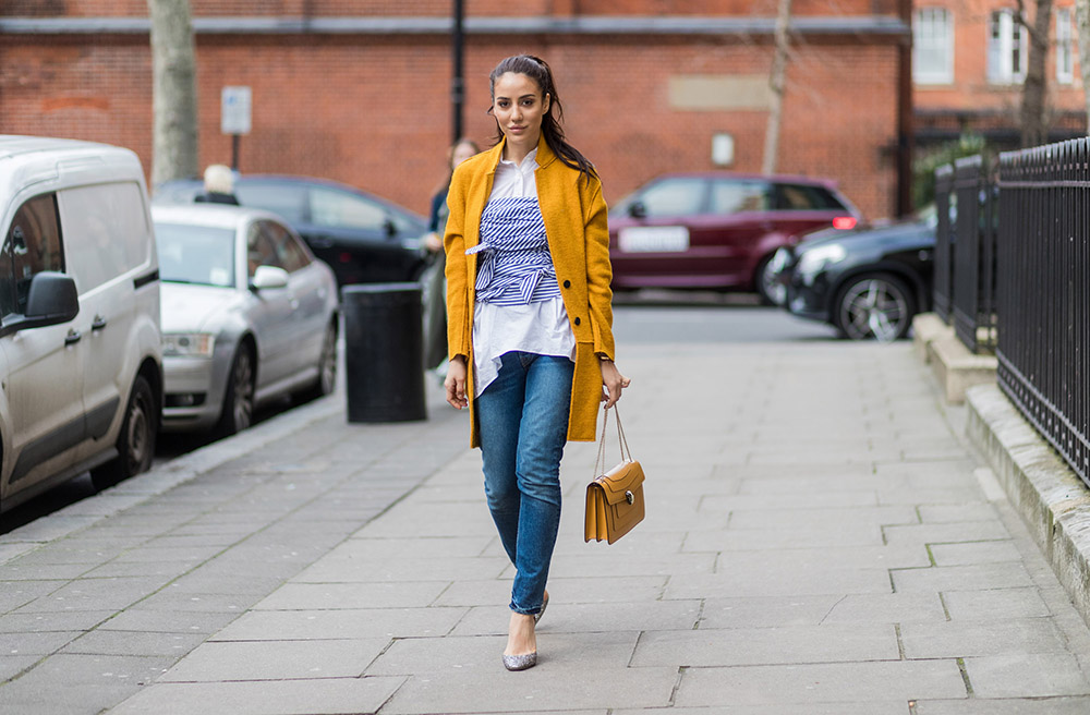 LONDON, ENGLAND - FEBRUARY 19: Tamara Kilic wearing mustard wool coat, denim jeans, Bulgari bag outside Anya Hindmarch on day 3 of the London Fashion Week February 2017 collections on February 19, 2017 in London, England. (Photo by Christian Vierig/Getty Images)