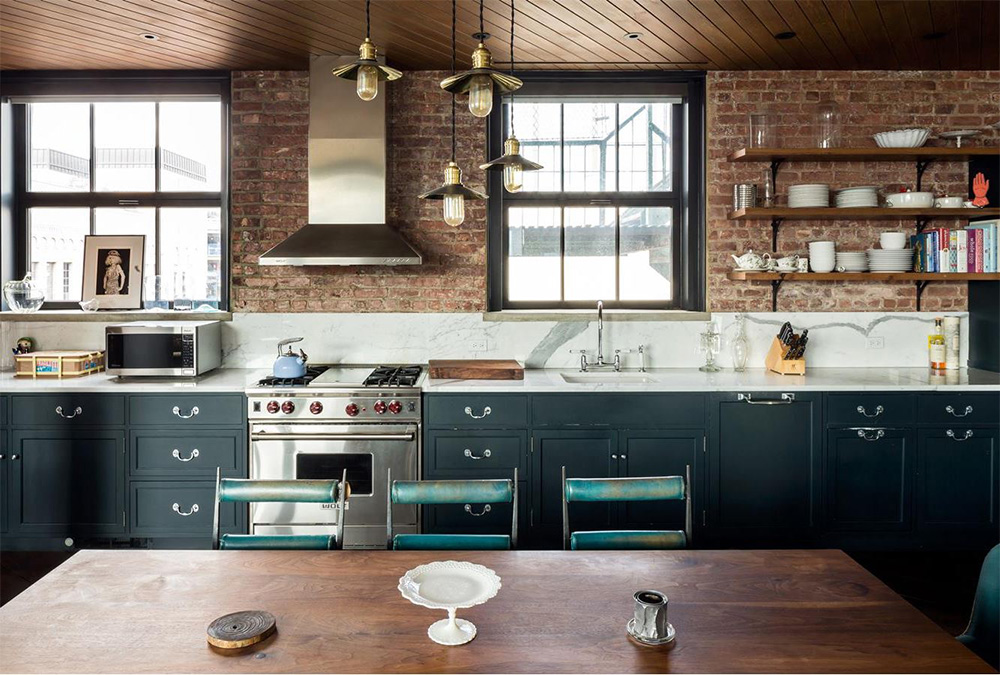 The open-plan kitchen has received the same industrial treatment, with exposed brick, open shelving, brass pendants and marble benchtops for a luxe touch.