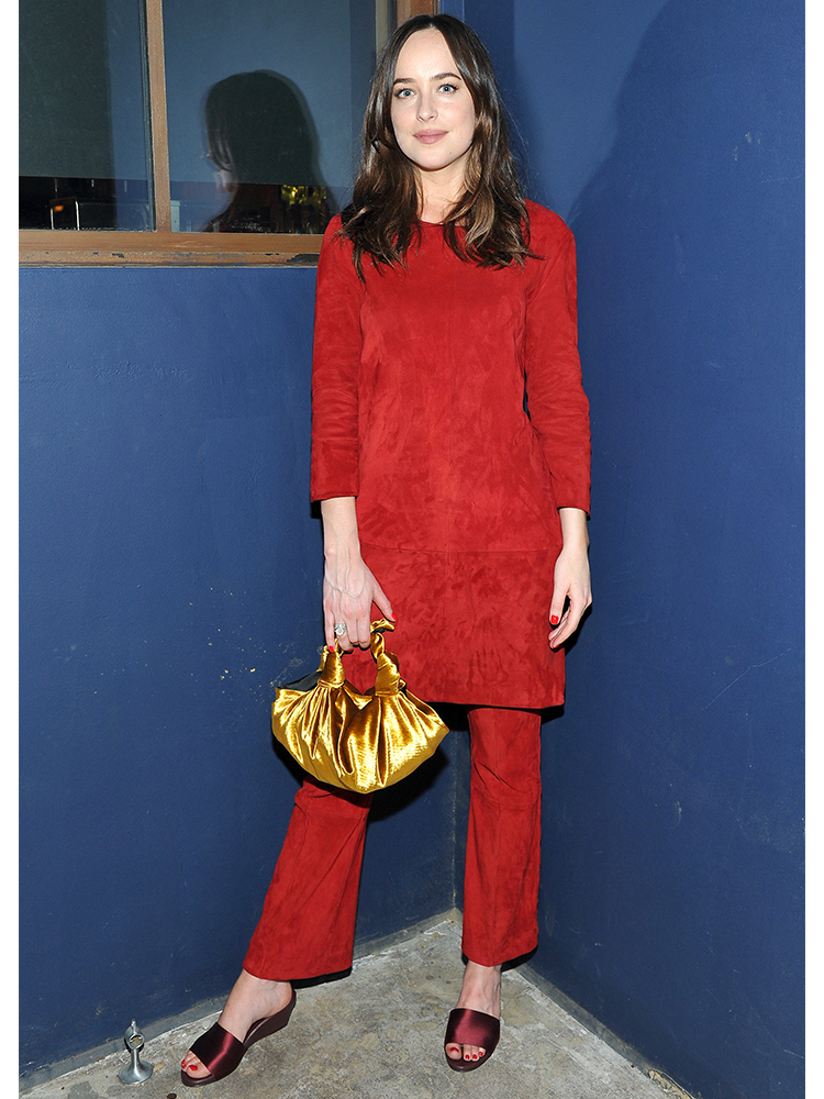 Dakota Johnson proved to be a master of colour blocking in a Jitrois Paris Kourou red mini dress over The Row suede pants. Her bag is the Ascot from the Row too.