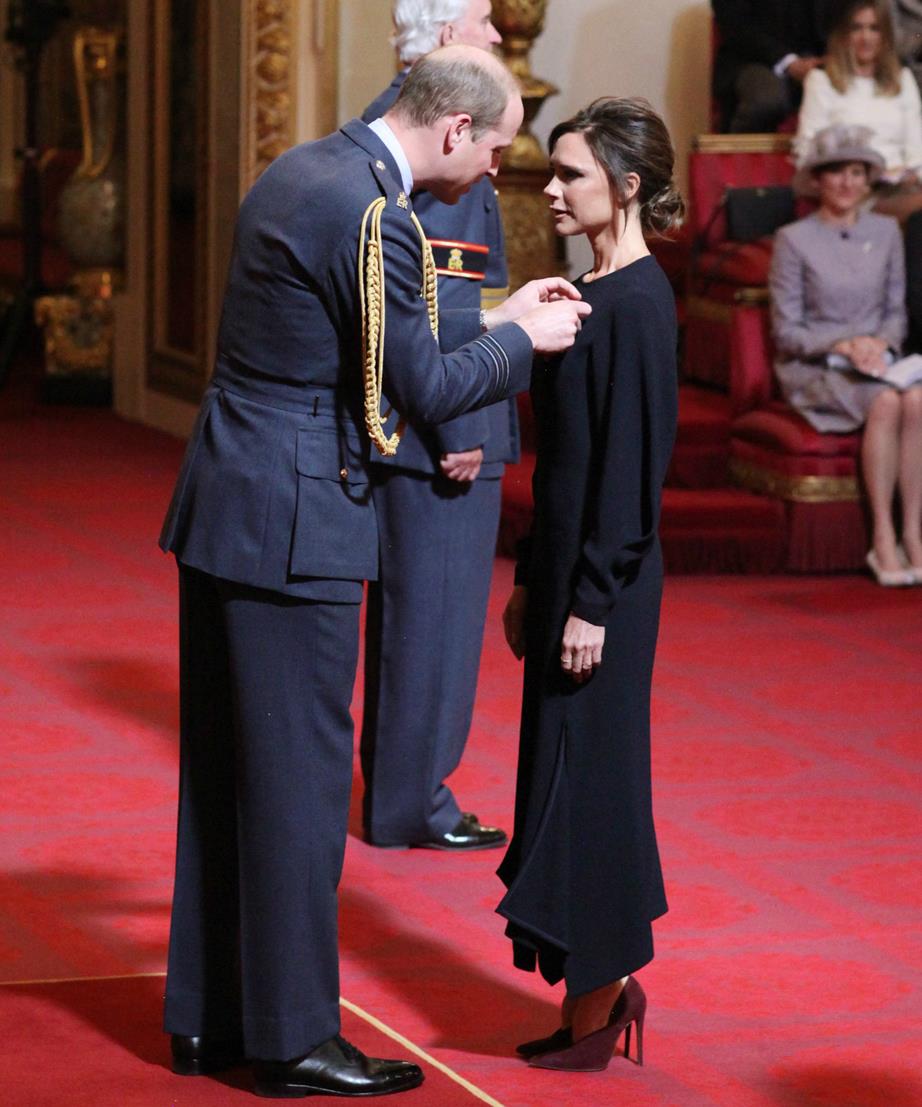 Victoria Beckham is presented her OBE by Prince William