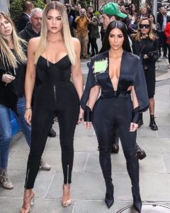 Kim and Khloe Kardashian stand in the street