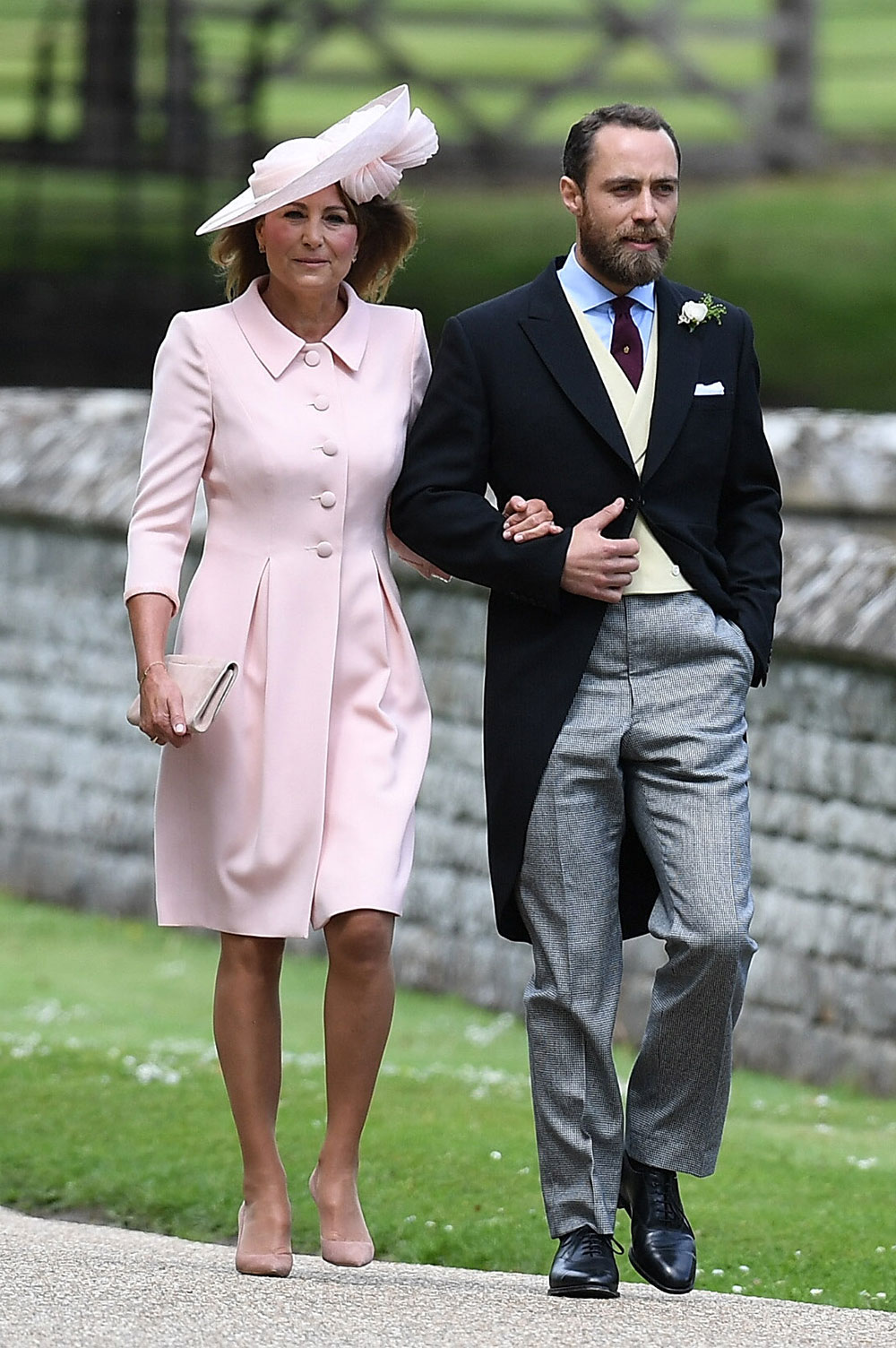 Pippa's mother, Carole Middleton, arrives on the arm of her son James Middleton.