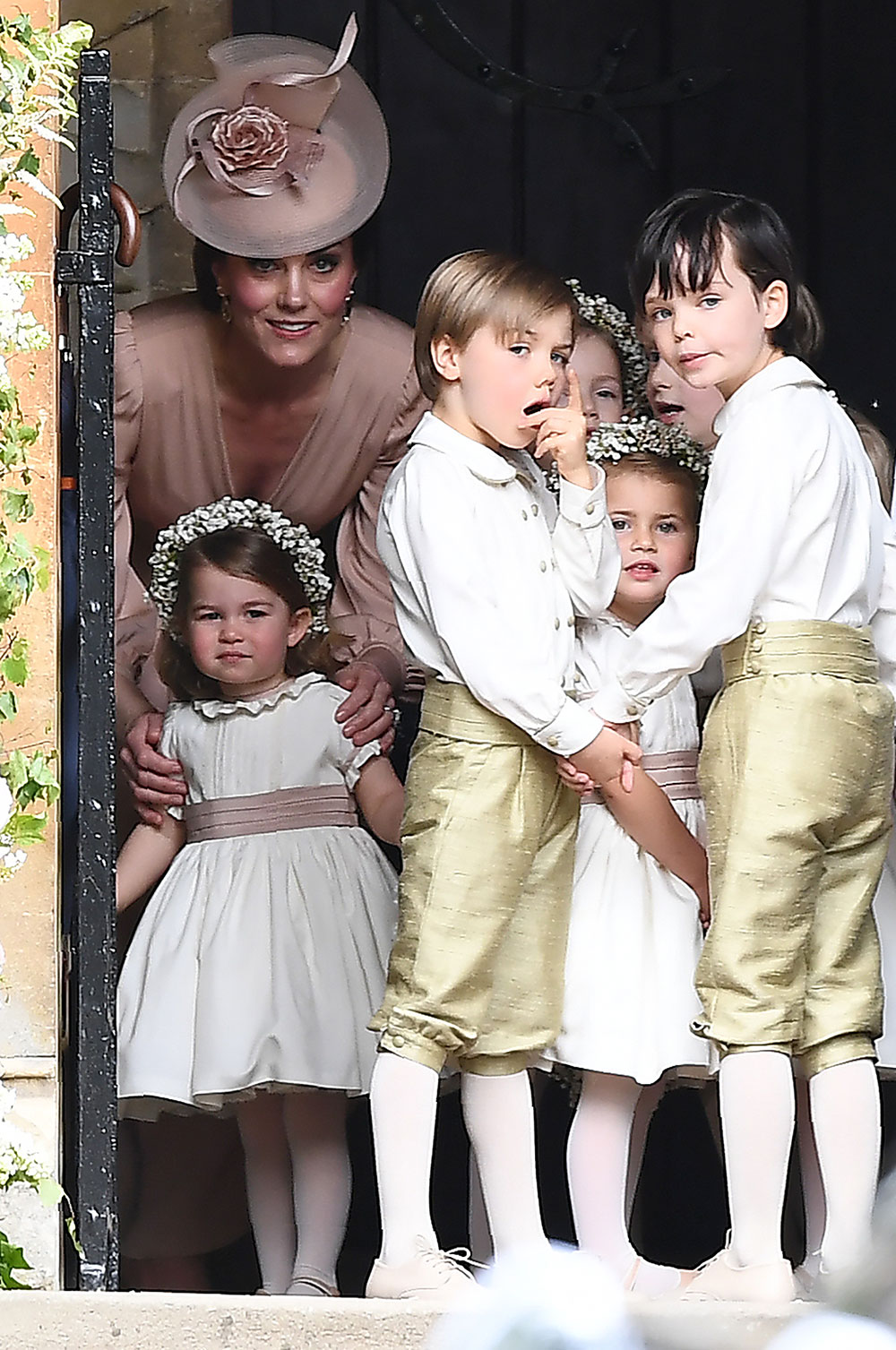 The Duchess of Cambridge leads the flower girls and page boys, including her own children Prince George and Princess Charlotte, into the church.