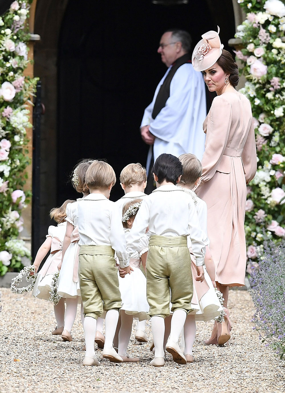 The Duchess of Cambridge leads the flower girls and page boys, including her own children Prince George and Princess Charlotte, into the church.