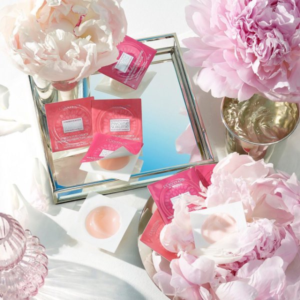 L'Occitane Pivione Sublime masks on a flat lay photo with pink flowers
