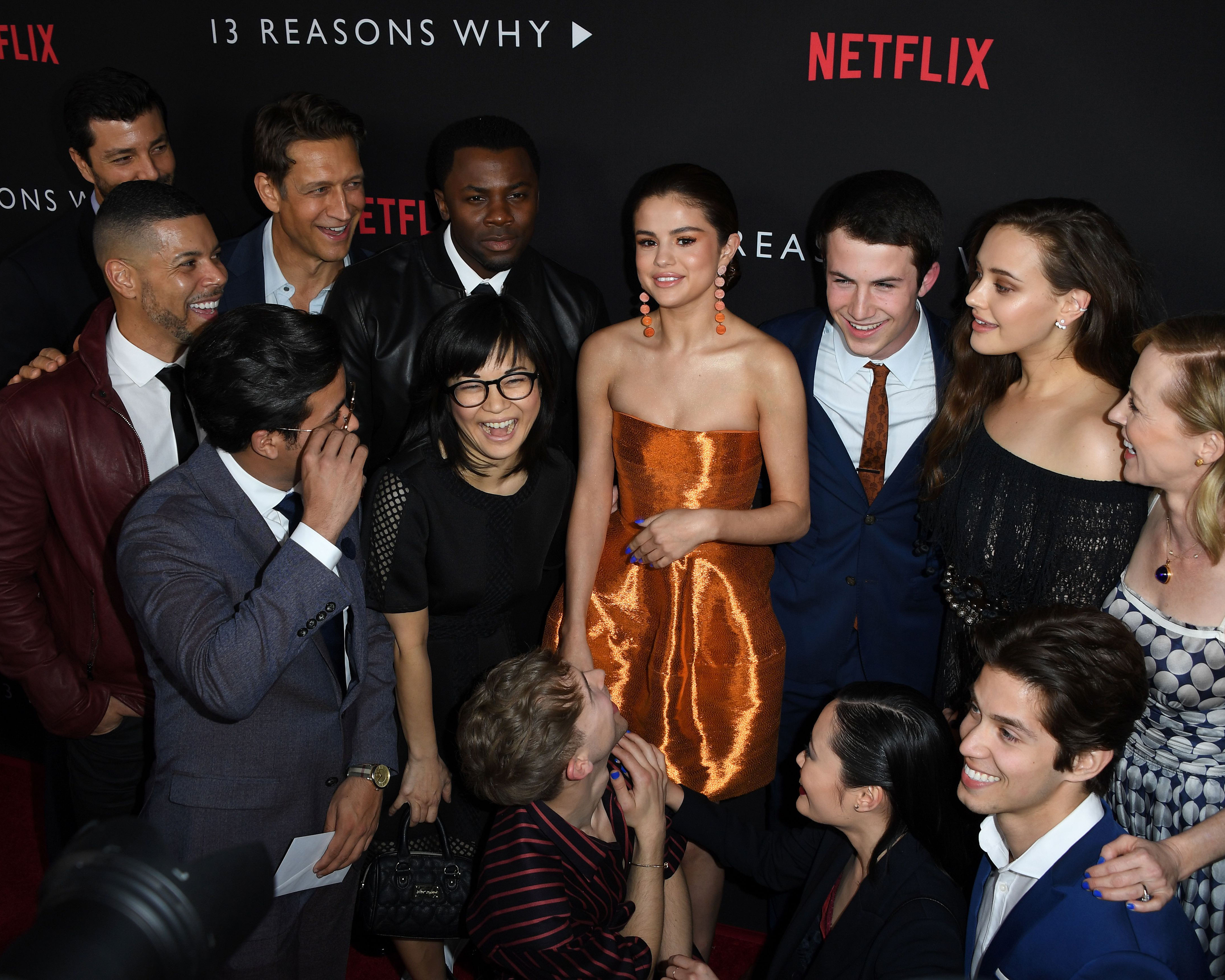 Actress/singer Selena Gomez (C) is surrounded by cast members as they arrive for the premiere Of Netflix's '13 Reasons Why' at Paramount Pictures Studio in Los Angeles, California on March 30, 2017.  / AFP PHOTO / Mark RALSTON        (Photo credit should read MARK RALSTON/AFP/Getty Images)
