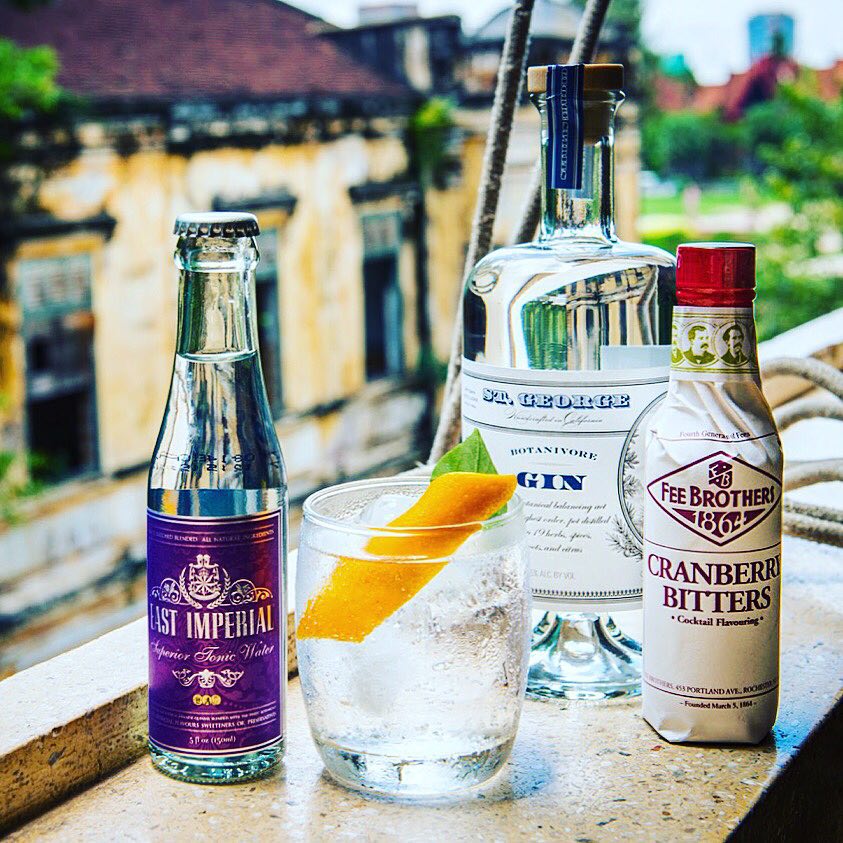 Gin and Tonic with ingredients sit on a window ledge overlooking a cityscape