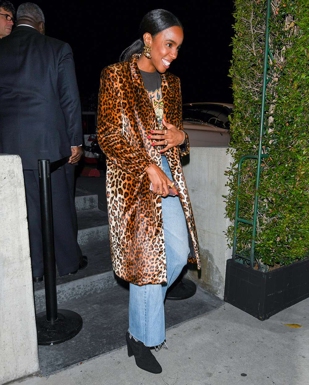 Kelly Rowland in a band t-shirt, jeans and a leopard print jacket.