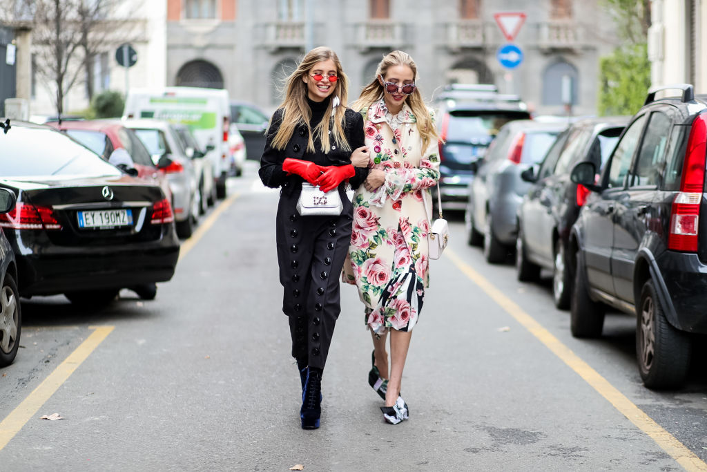 MILAN, ITALY - FEBRUARY 25: Xenia van der Woodsen wearing red leather gloves, silver bag and Leonie Sophie Hanne wearing floral print jacket and skirt is seen outside Dolce & Gabbana during Milan Fashion Week Fall/Winter 2018/19 on February 25, 2018 in Milan, Italy. (Photo by Christian Vierig/Getty Images)