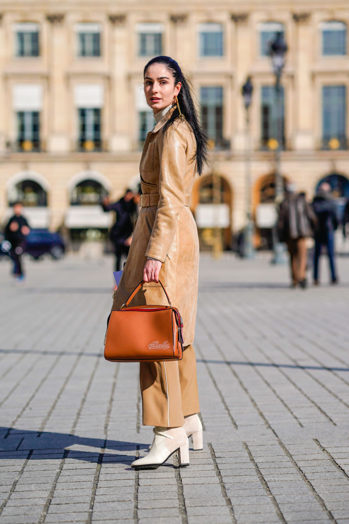 PARIS, FRANCE - FEBRUARY 28: Fiona Zanetti wears a beige leather coat, flare brown pants, a brown bag, white shoes, during Paris Fashion Week Womenswear Fall/Winter 2018/2019, on February 28, 2018 in Paris, France. (Photo by Edward Berthelot/Getty Images)