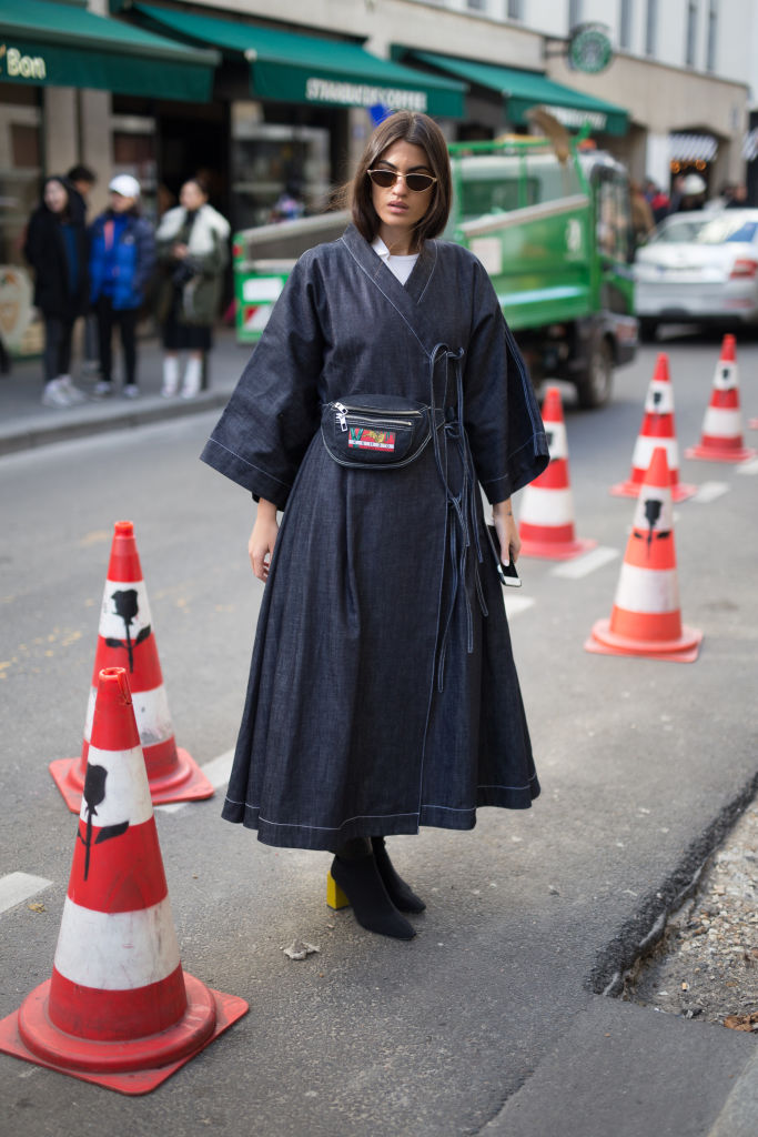 PARIS, FRANCE - FEBRUARY 28: A guest is seen on the street attending AALTO during Paris Fashion Week Women's A/W 2018 Collection wearing a long navy coat with hip bag on February 28, 2018 in Paris, France. (Photo by Matthew Sperzel/Getty Images)