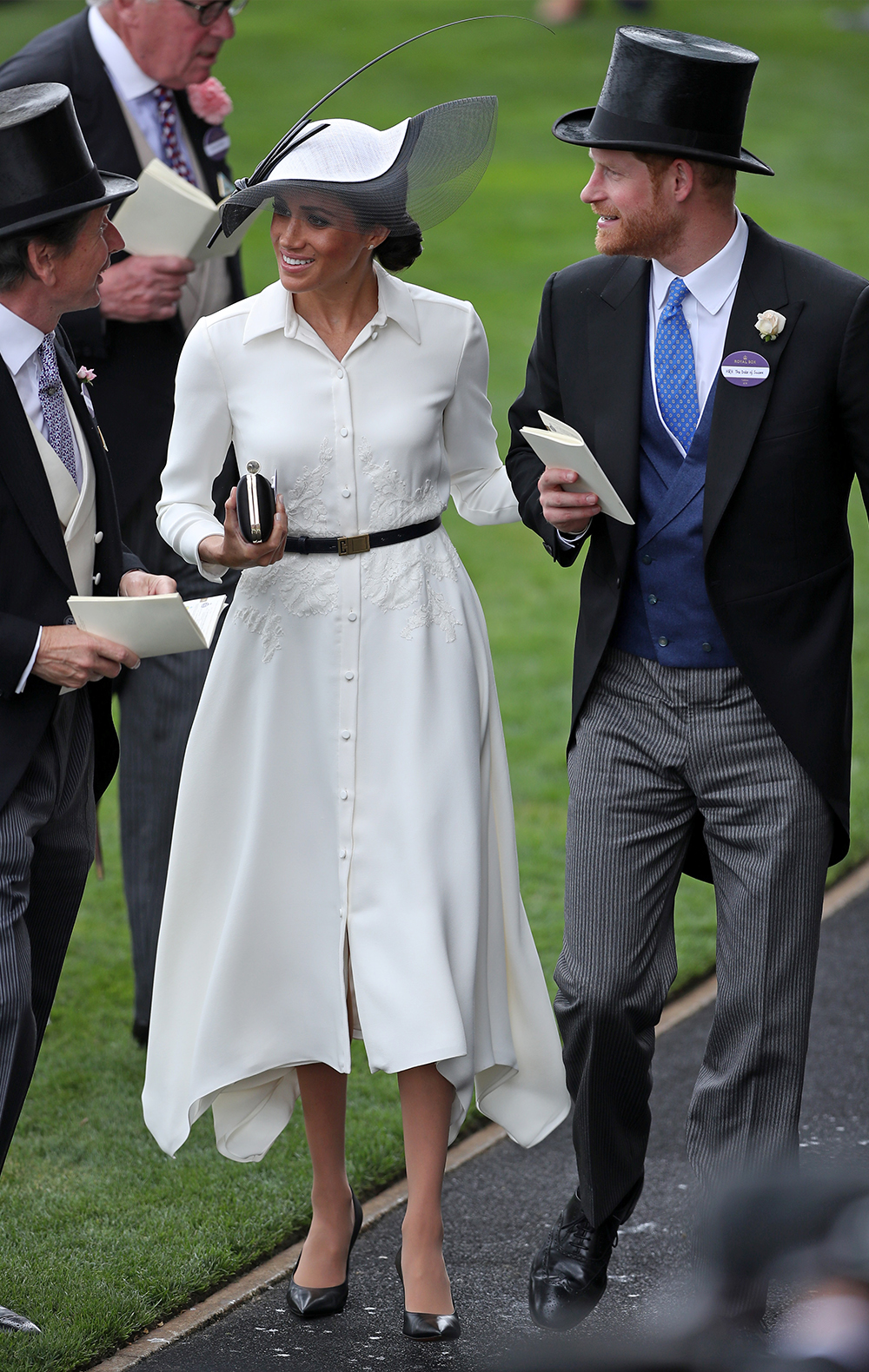 June 19, 2018: Meghan showing her proclivity towards a white dress with a black belt at her first Royal Ascot alongside husband Prince Harry. The dress is Givenchy - the same designer behind her wedding gown -and a Philip Treacy hat. 