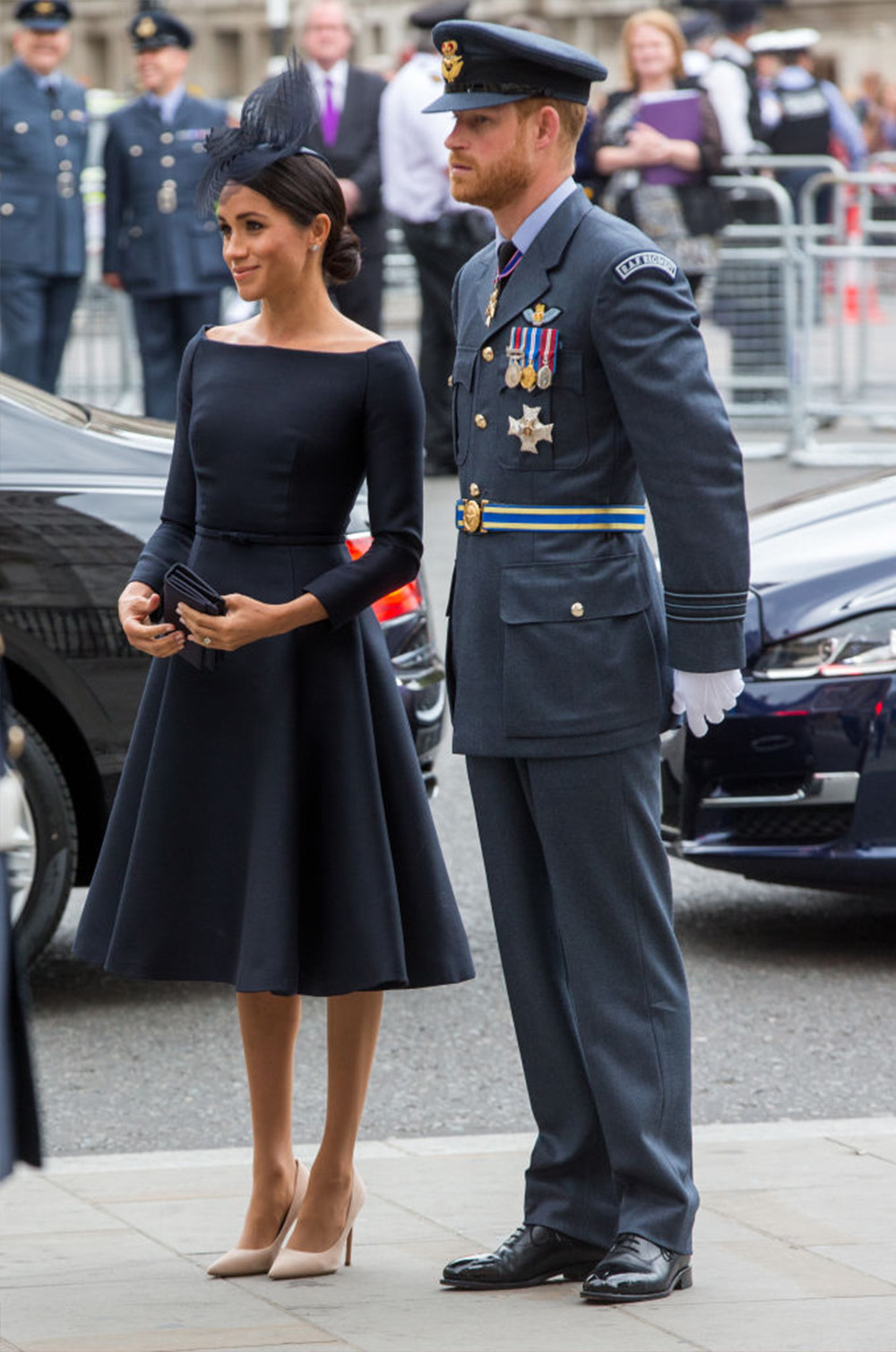 July 10, 2018: Meghan, Duchess of Sussex, wearing a black Dior dress again with a neckline reminiscent of her wedding dress to Westminster Abbey to mark the centenary of the Royal Air Force. The elegant style is accessorised with a black headpiece by royal family favourite Stephen Jones and (simple) black clutch and off-white heels both also by Dior.