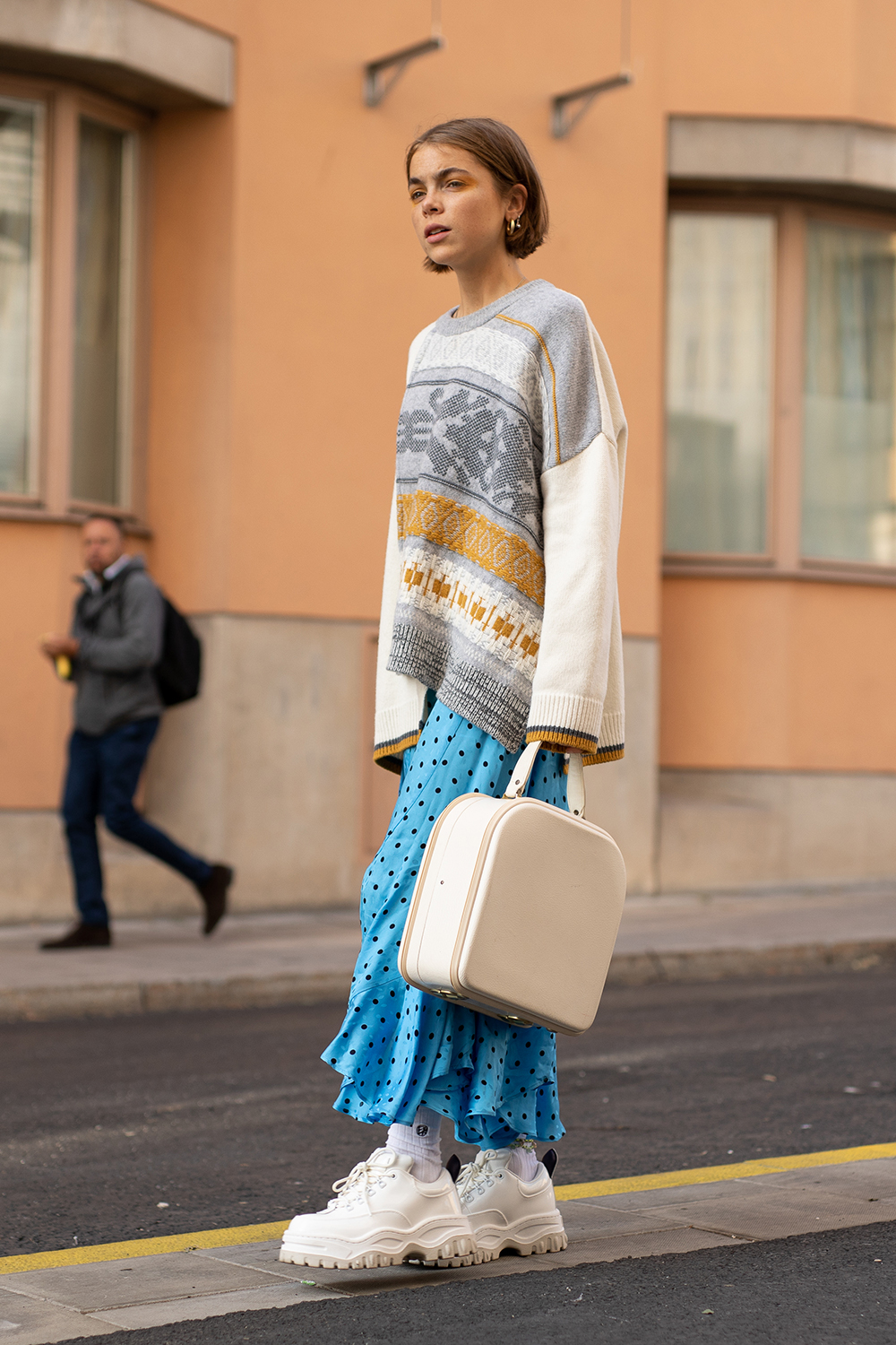 STOCKHOLM, SWEDEN - AUGUST 29: A guest is seen on the street during Fashion Week Stockholm SS19 wearing a grey/gold pattern sweater with blue skirt, white sneakers and vintage jewelry box bag on August 29, 2018 in Stockholm, Sweden. (Photo by Matthew Sperzel/Getty Images)