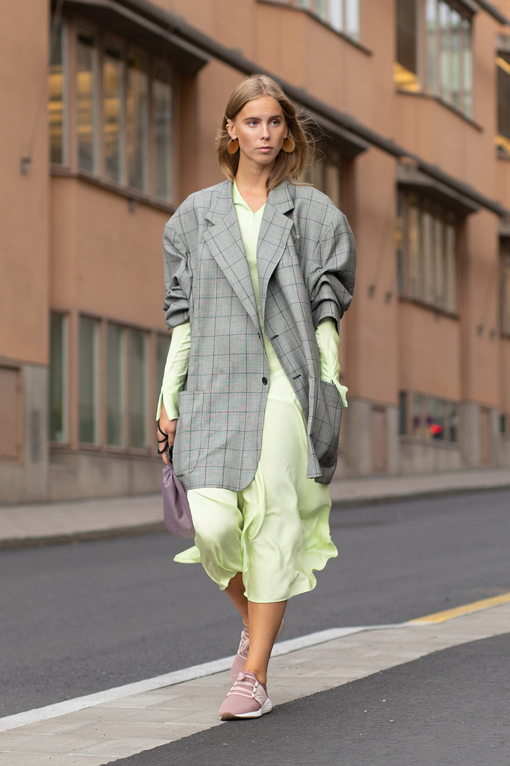 STOCKHOLM, SWEDEN - AUGUST 30: A guest is seen on the street during Fashion Week Stockholm SS19 wearing grey coat with neon green dress and nude pink New Balance sneakers on August 30, 2018 in Stockholm, Sweden. (Photo by Matthew Sperzel/Getty Images)