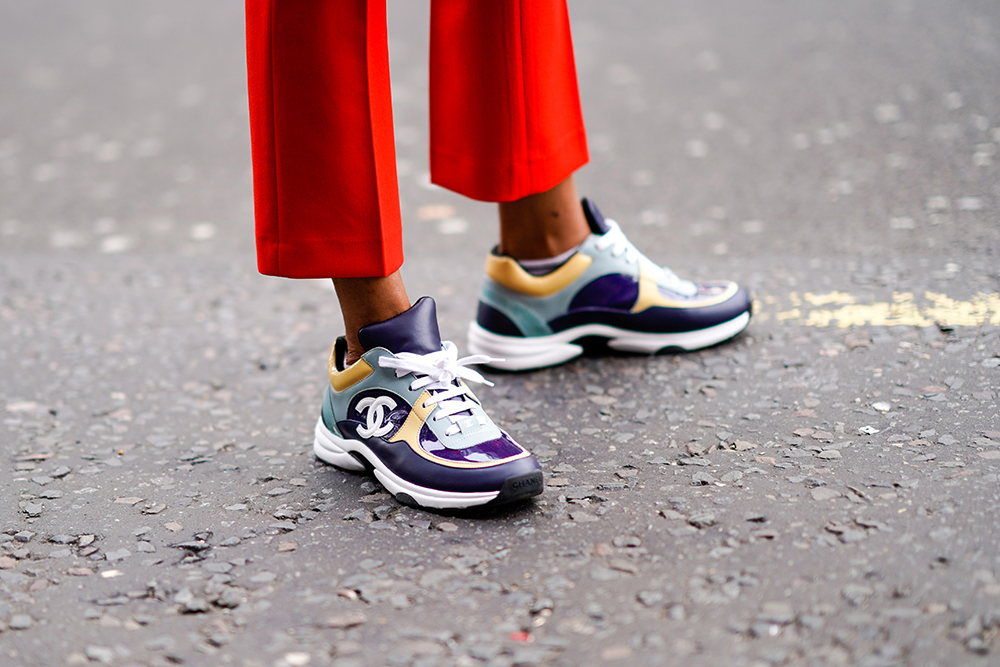 A guest wears Chanel sneaker shoes, during London Fashion Week September 2018 on September 14, 2018 in London, England. (Photo by Edward Berthelot/Getty Images)