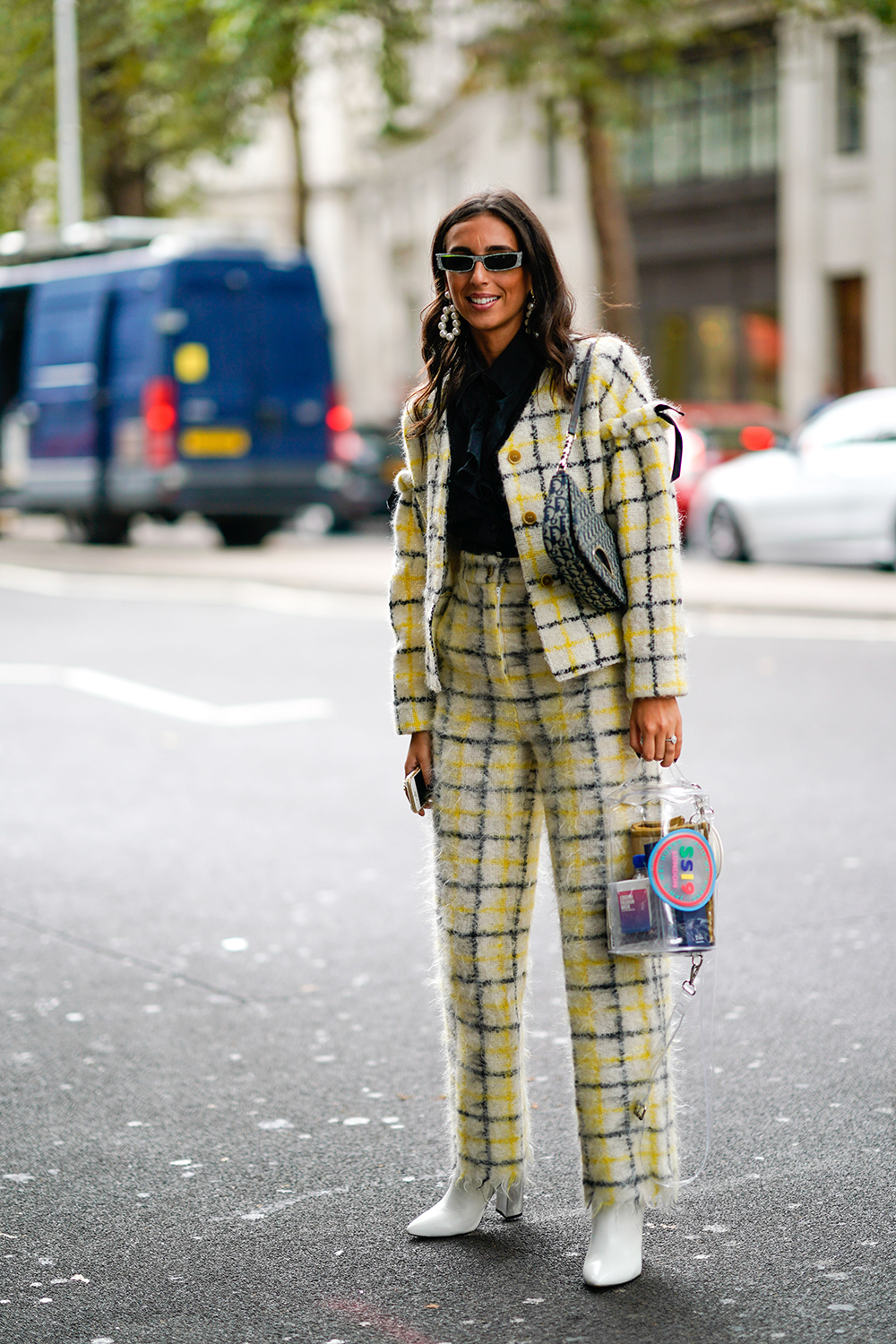 A guest wears a Dior bag, a yellow checked jacket pants, white shoes, during London Fashion Week September 2018 on September 14, 2018 in London, England. (Photo by Edward Berthelot/Getty Images)
