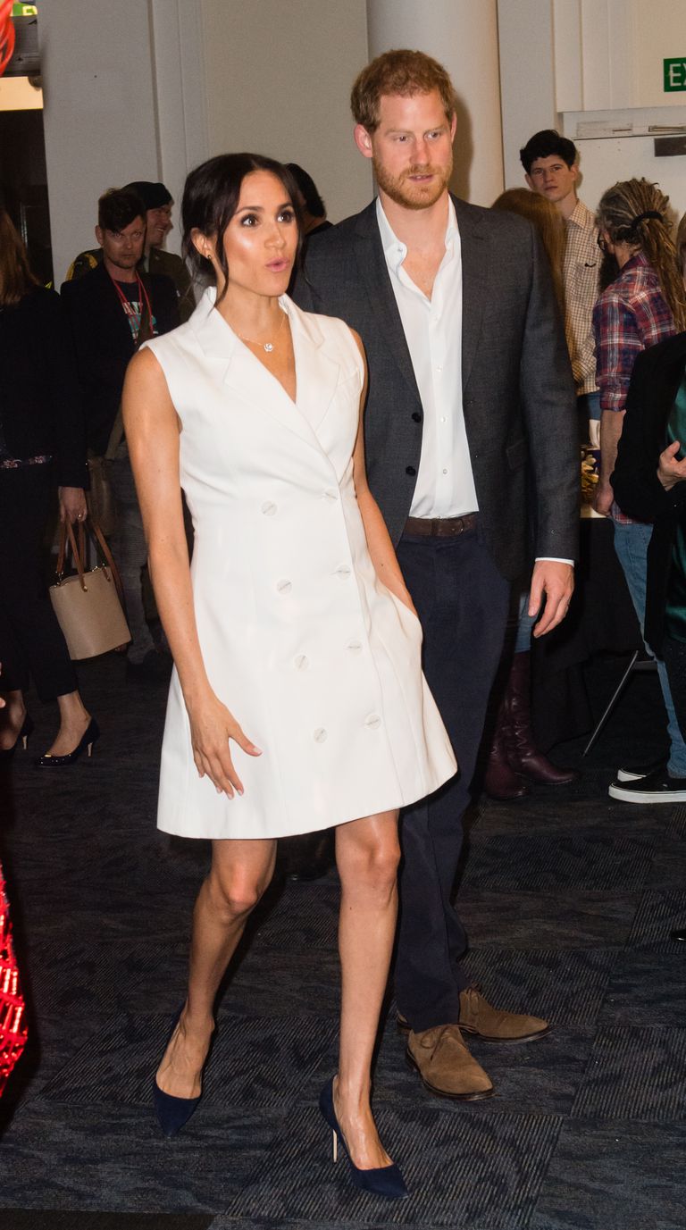 October 29, 2018: Meghan, Duchess of Sussex wears custom New Zealand luxury and sustainable conscious designer Maggie Marilyn to Courtenay Creative on her and husband Prince Harry’s second day in the country. The white ‘Leap of Faith’ dress has the sleeves removed; the second tuxedo dress in the Duchess’s “tourdrobe”. Meghan, wore it with the Jessica McCormack Tattoo diamond pendant, black suede pumps and her signature low-swept bun.