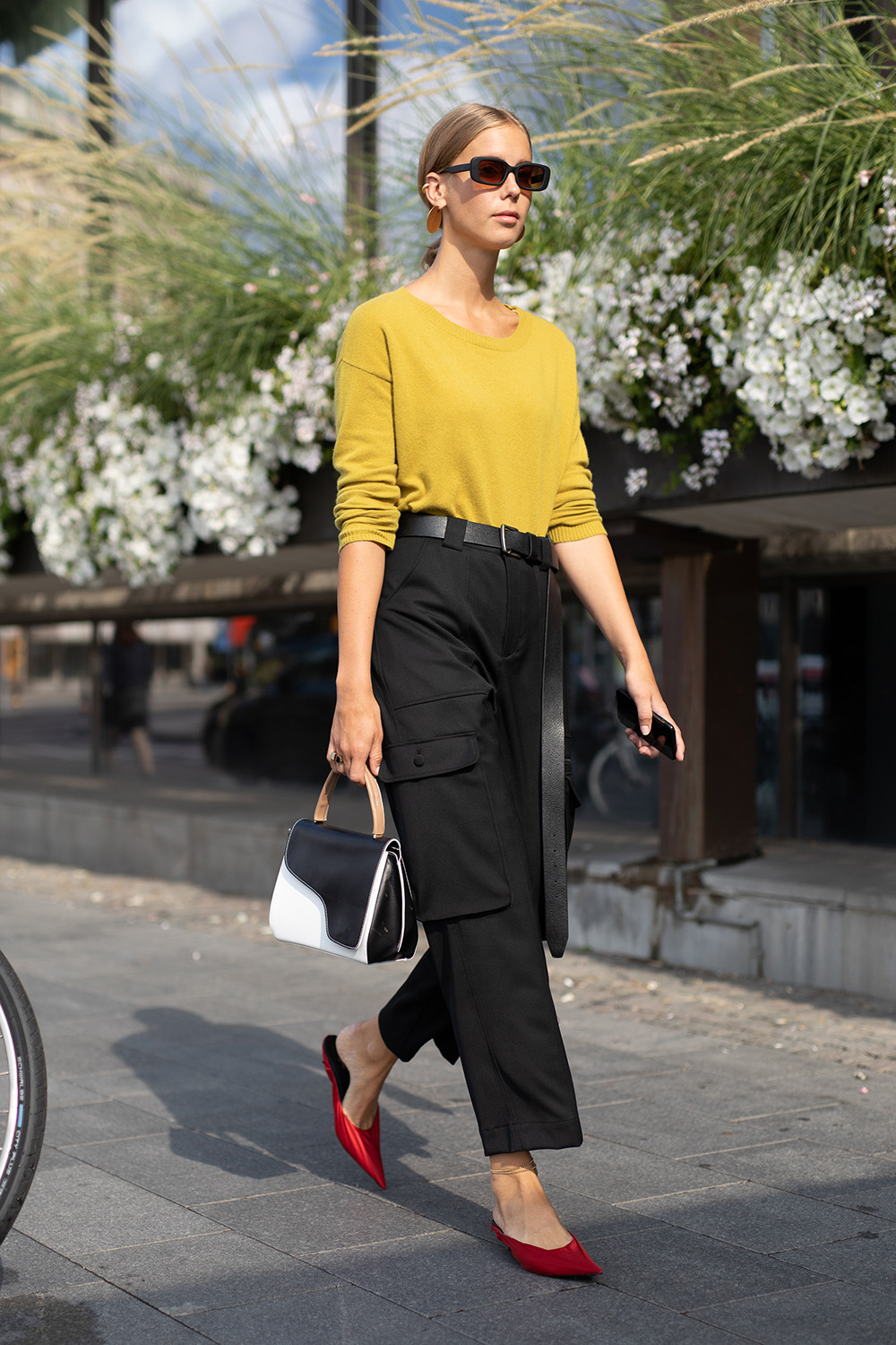 Precious Cargo: The practical pant trend that’s replacing your mom jeans (and fast) |STOCKHOLM, SWEDEN - AUGUST 28: A guest is seen on the street during Fashion Week Stockholm wearing a yellow sweater with black cargo pants and red heels on August 28, 2018 in Stockholm, Sweden. (Photo by Matthew Sperzel/Getty Images)