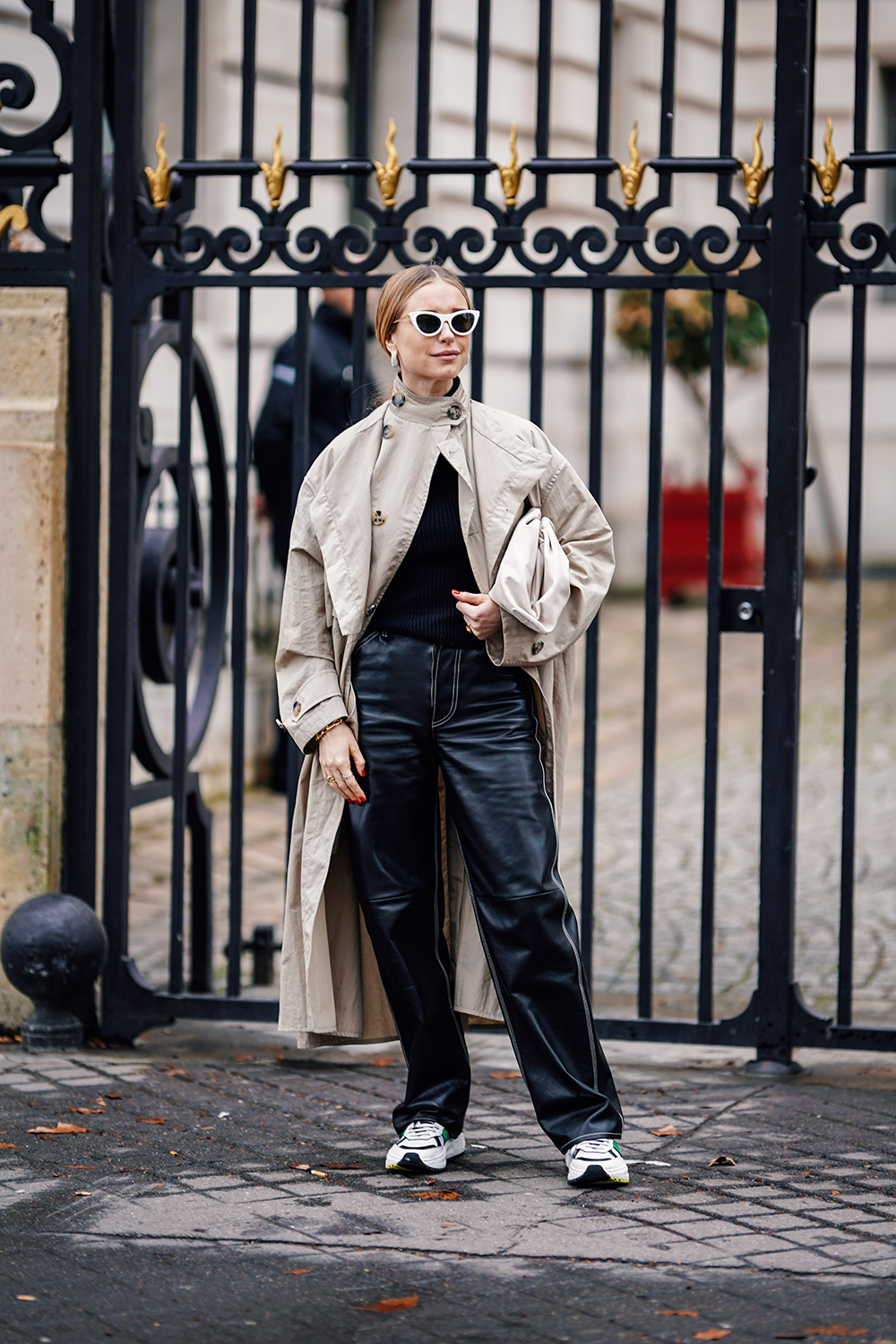 PARIS, FRANCE - MARCH 02: Pernille Teisbaek wears earrings, white sunglasses, a beige trench coat, black leather pants, white sneakers, a beige bag, outside Altuzarra, during Paris Fashion Week Womenswear Fall/Winter 2019/2020, on March 02, 2019 in Paris, France. (Photo by Edward Berthelot/Getty Images)