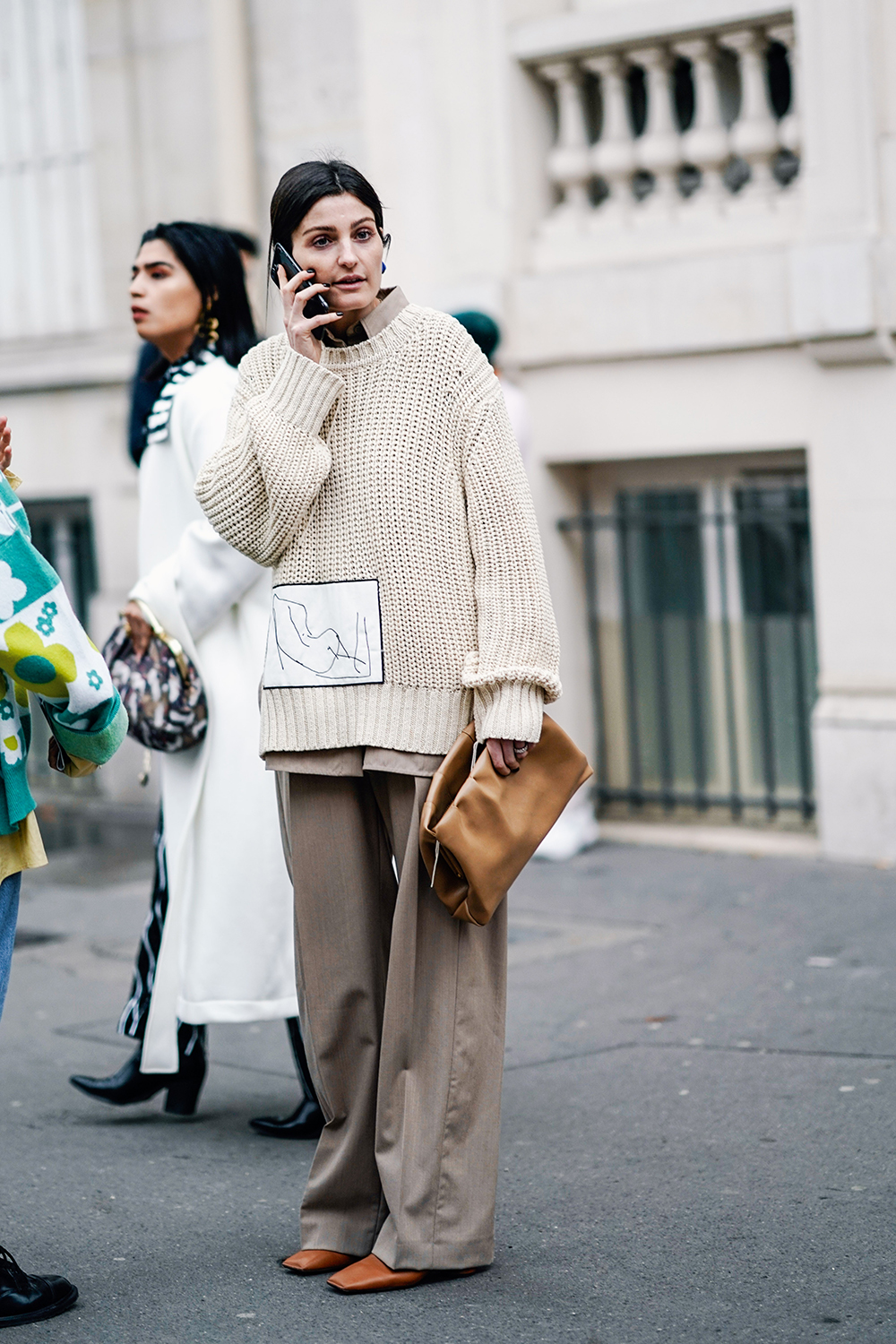 PARIS, FRANCE - MARCH 01: A guest wears a cream color sweater, light brown wide-leg pants, a camel bag, gold leather shoes, outside Issey Miyake, during Paris Fashion Week Womenswear Fall/Winter 2019/2020, on March 01, 2019 in Paris, France. (Photo by Edward Berthelot/Getty Images)