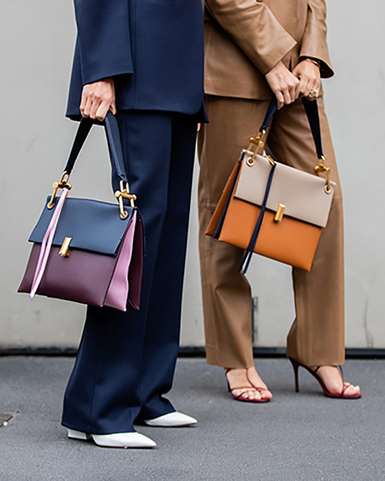 MILAN, ITALY - SEPTEMBER 22: Erika Boldrin wearing brown leather suit, bag, Linda Tol wearing navy suit, two tone bag seen outside Boss during Milan Fashion Week Spring/Summer 2020 on September 22, 2019 in Milan, Italy. (Photo by Christian Vierig/Getty Images)