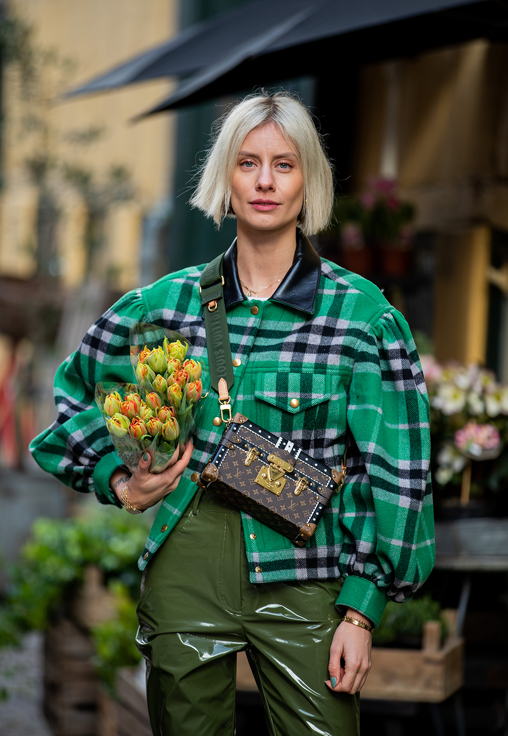 COPENHAGEN, DENMARK - JANUARY 29: Lisa Hahnbueck seen with some flower wearing green checkered Louis Vuitton jacket green shiny patent leather pants Tibi, Üterque boots, LV petite Malle bag during Copenhagen Fashion Week Autumn/Winter 2020 Day 2 on January 29, 2020 in Copenhagen, Denmark. (Photo by Christian Vierig/Getty Images)