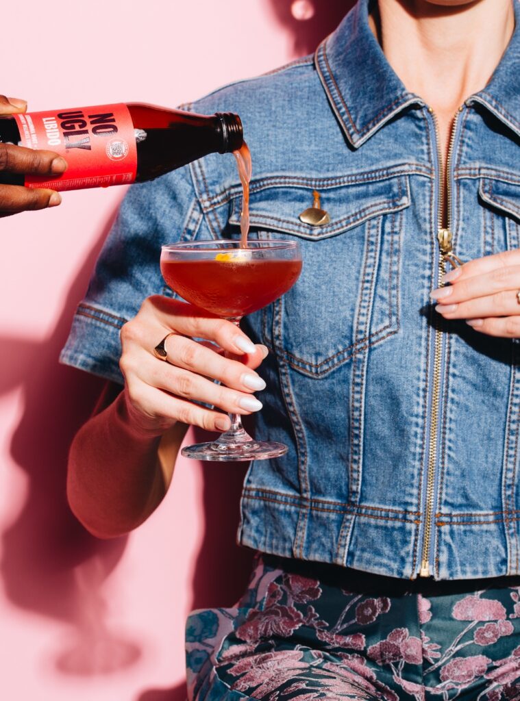 Image of woman at QT Hotel holding a glass of their exclusive Valentine's Day cocktail in partnership with No Ugly 'Libido'.