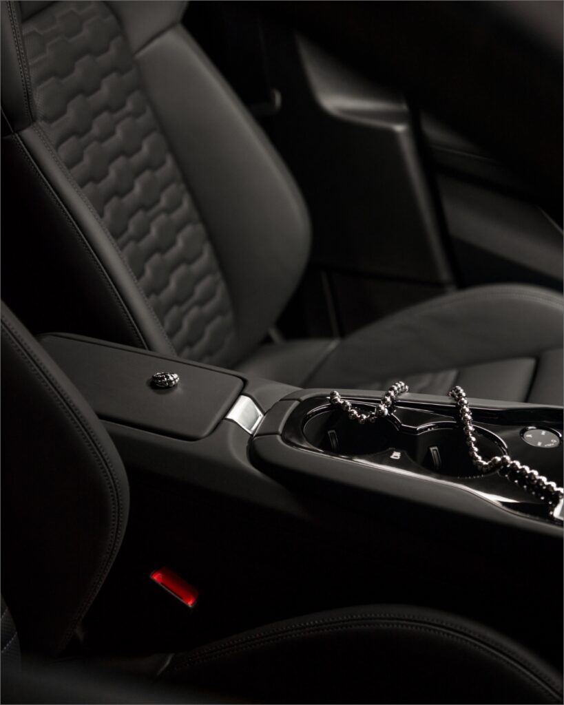 Detailed shot of the Audi RS e-tron GT's interior juxtaposed with designer accessories, highlighting the blend of technology and style.