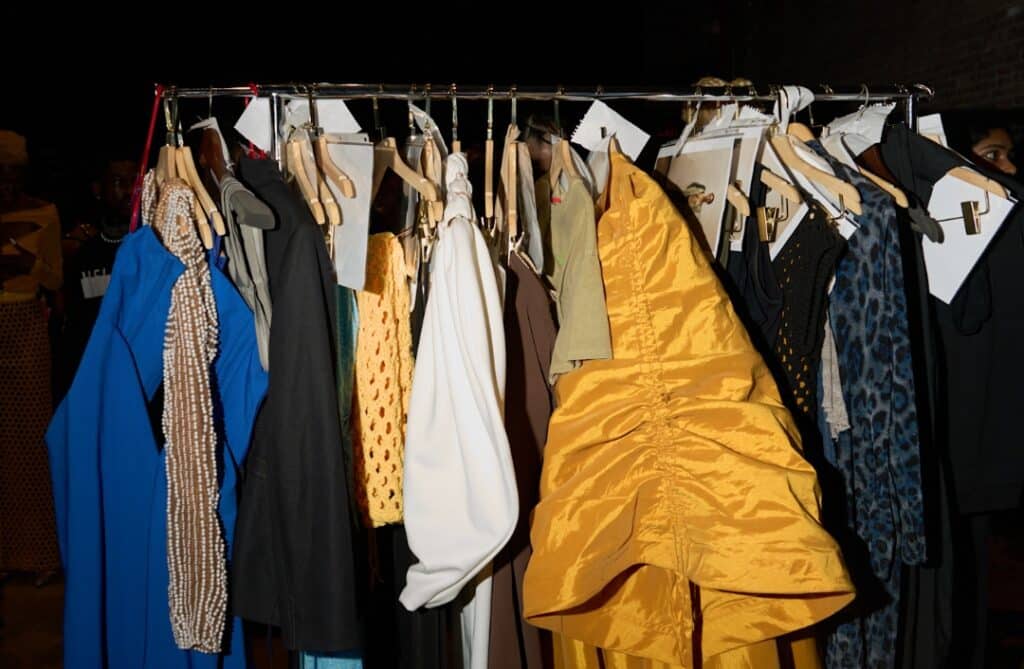 A backstage look at Fashion Week: stylish racks filled with designer clothing ready for the runway.